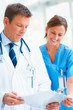 Foto: Happy young doctor and nurse reading from a writing pad Happy young doctor and nurse reading from a writing pad