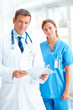 Foto: Happy young doctor while standing with a pretty nurse Happy young doctor while standing with a pretty nurse