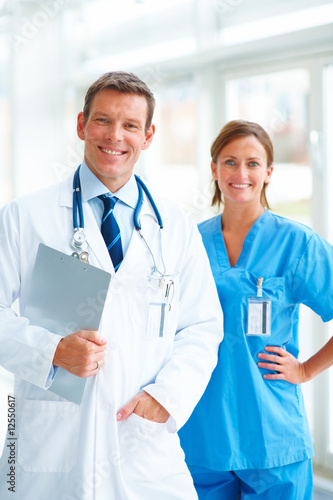 Foto: Smiling young doctor while standing with a pretty nurse Smiling young doctor while standing with a pretty nurse