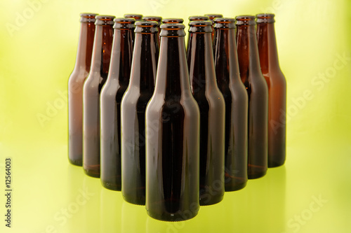 Photo: Empty beer bottles in front of a bright green background Empty beer bottles in front of a bright green background