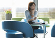 A woman sitting at a table with notes and papers, thinking