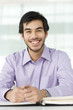 A man sitting at a desk, smiling