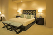 Side view of a double bed between two table lamps