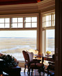 Photo: A dining table is placed near the large window as the landscape is viewed through it A dining table is placed near the large window as the landscape is viewed through it