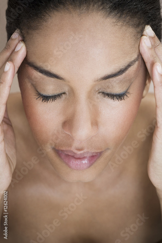Photo: A woman with her fingers resting on her temples A woman with her fingers resting on her temples