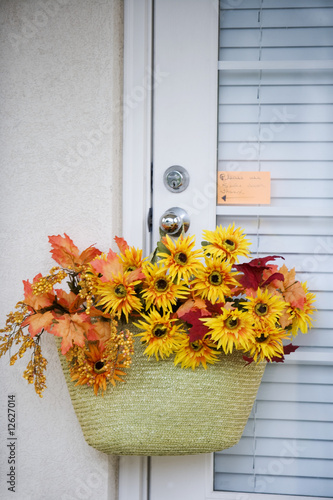 Photo: Autumnal flowers in a basket hanging from a doorknob Autumnal flowers in a basket hanging from a doorknob