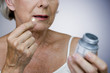 A senior woman holding a bottle of pills