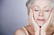 A senior woman with head resting in hands