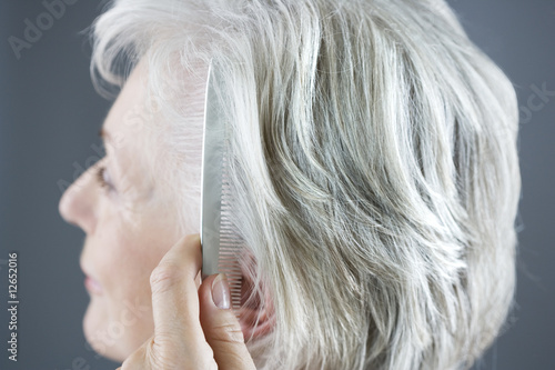 Photo: A senior woman combing her hair A senior woman combing her hair