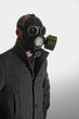 Man with coat wearing gas mask