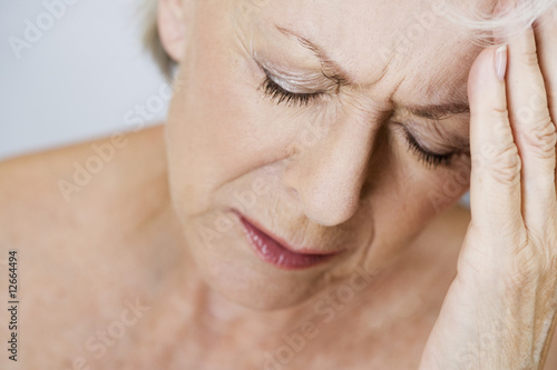 Photo: A senior woman with a headache, touching temples A senior woman with a headache, touching temples