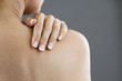 A woman with her hand on her shoulder