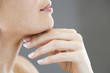 A middle-aged woman touching her neck