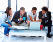 Business team sitting together and working on a laptop