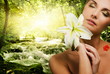 Beautiful young woman with flower in forest Beautiful young woman with flower in forest