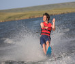 Man slalom waterkiing and waving