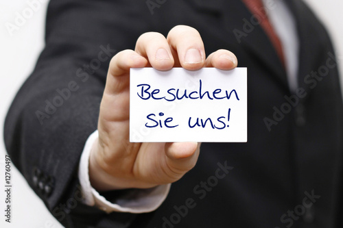 Foto: Mann hält Karte mit Besuchen Sie uns Mann hält Karte mit Besuchen Sie uns