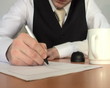 businessman writing on piece paper
