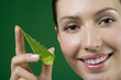 Photo: Close up woman holding piece of aloe plant Close up woman holding piece of aloe plant