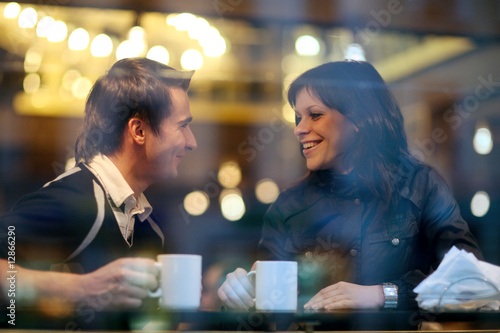 Photo: Happy young couple in cafe, having a great time together Happy young couple in cafe, having a great time together