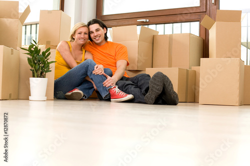 Couple on floor next to moving boxes