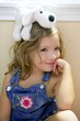 Happy toddler girl with toy dog over head