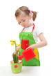Little girl watering daffodil with a watering can toy