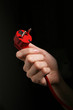 Hand holding power plug isolated on black background