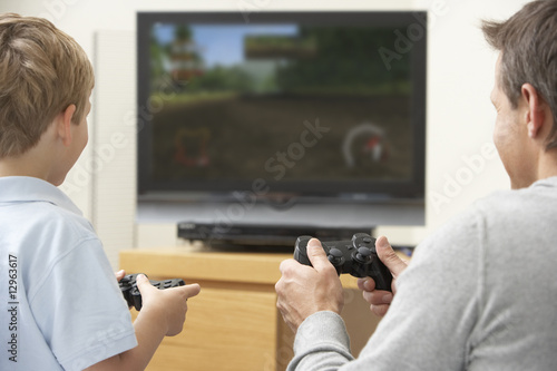 Photo: Father And Young Son Playing With Game Console Father And Young Son Playing With Game Console