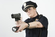 Police woman pointing handgun and holding flashlight.