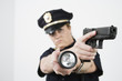 Police woman pointing handgun and holding flashlight.