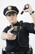 Police woman pointing handgun and holding flashlight.