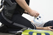 Police woman administering first aid to a person.