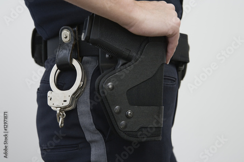 Photo: Female police woman with a holstered handgun Female police woman with a holstered handgun