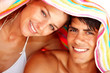 Closeup of a young man and woman covering their head
