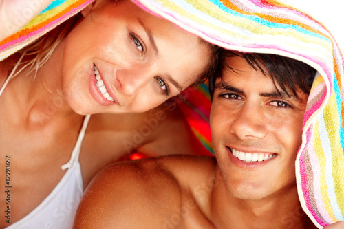 Photo: Closeup of a young man and woman covering their head Closeup of a young man and woman covering their head