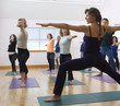Teacher guides student in yoga class