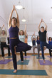 Teacher guides student in yoga class Teacher guides student in yoga class