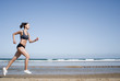 Junge Frau joggt am Strand