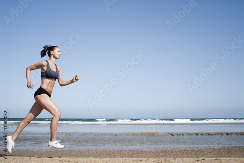 Foto: Junge Frau joggt am Strand Junge Frau joggt am Strand