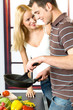 Young attractive happy smiling couple playfully cooking