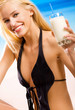Young beautiful smiling woman with milkshake in bikini