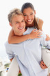 Lovely couple smiling over a white background - piggyback