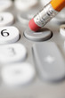 Pencil pushing subtraction button on calculator