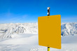 Empty yellow warning sign above mountains.