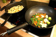 Preparing the meal - stir fry vegetables and potatoes in pan Preparing the meal - stir fry vegetables and potatoes in pan