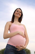 A pregnant woman at sky background