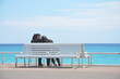 deux jeunes filles assisent sur un banc face à la mer