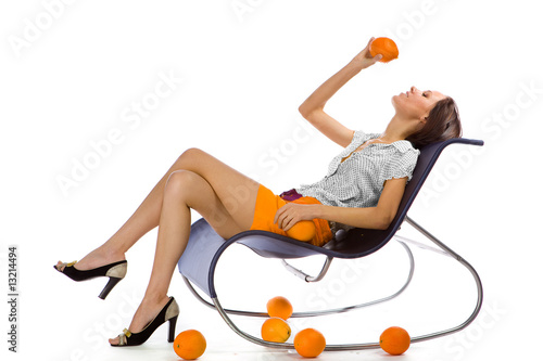 Photo: Cute girl with oranges on a white background Cute girl with oranges on a white background