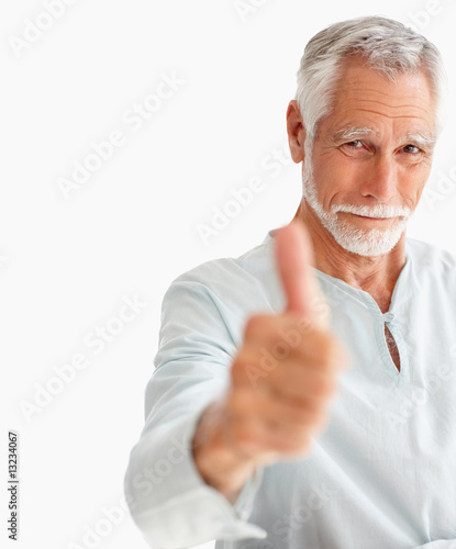 Photo: Portrait of a happy senior man showing a thumbs up on white Portrait of a happy senior man showing a thumbs up on white